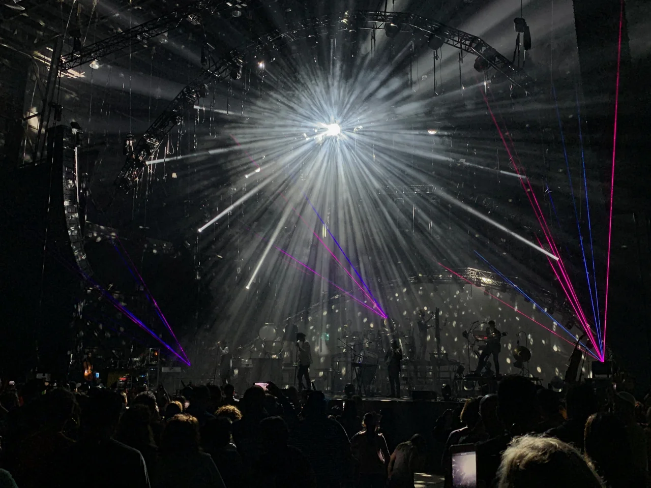 for KING & COUNTRY silhouetted beneath a burst of white light and crossing pink and blue lasers.