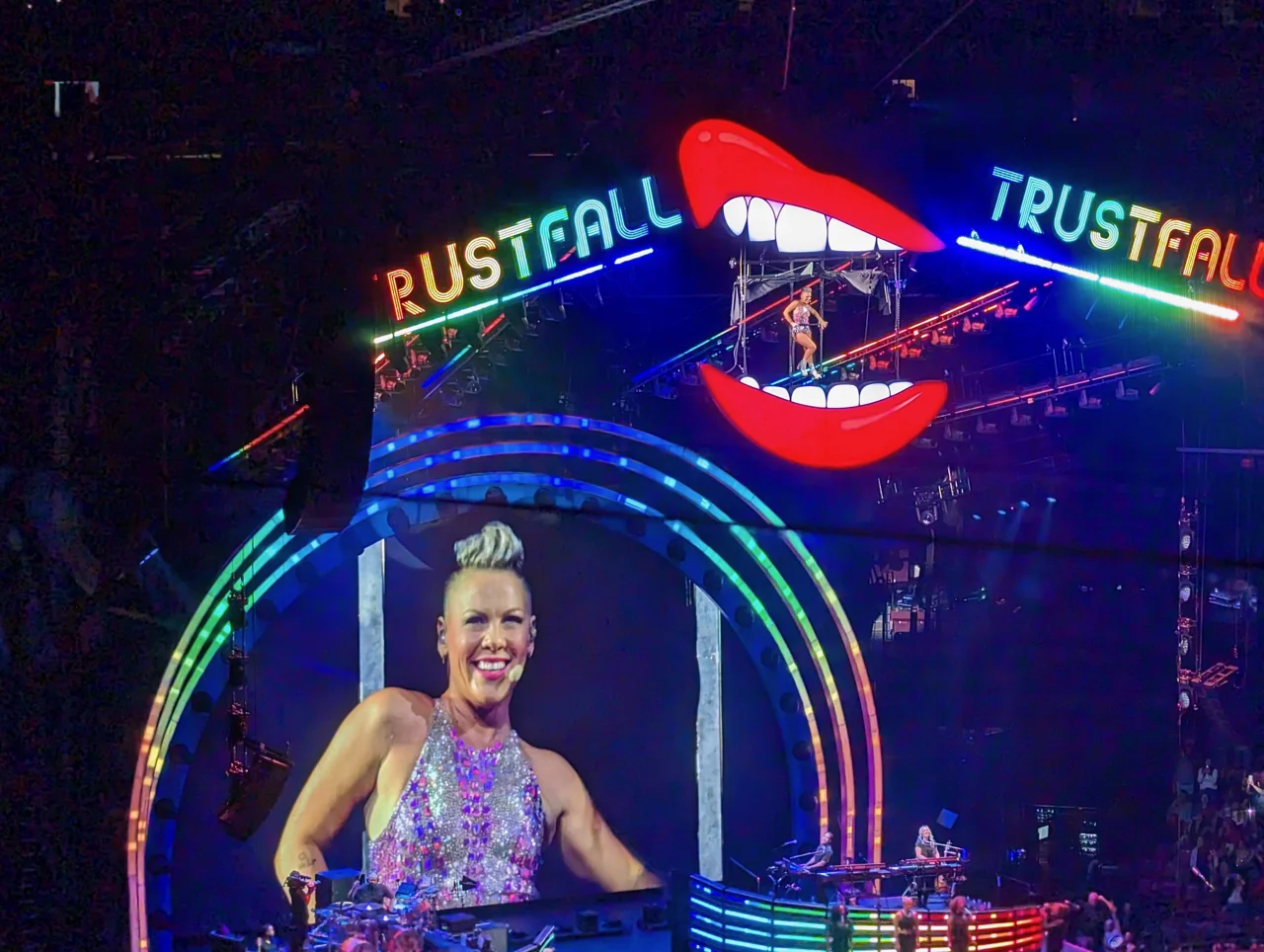 P!nk on the arena screen beneath a red lips-shaped stage structure.
