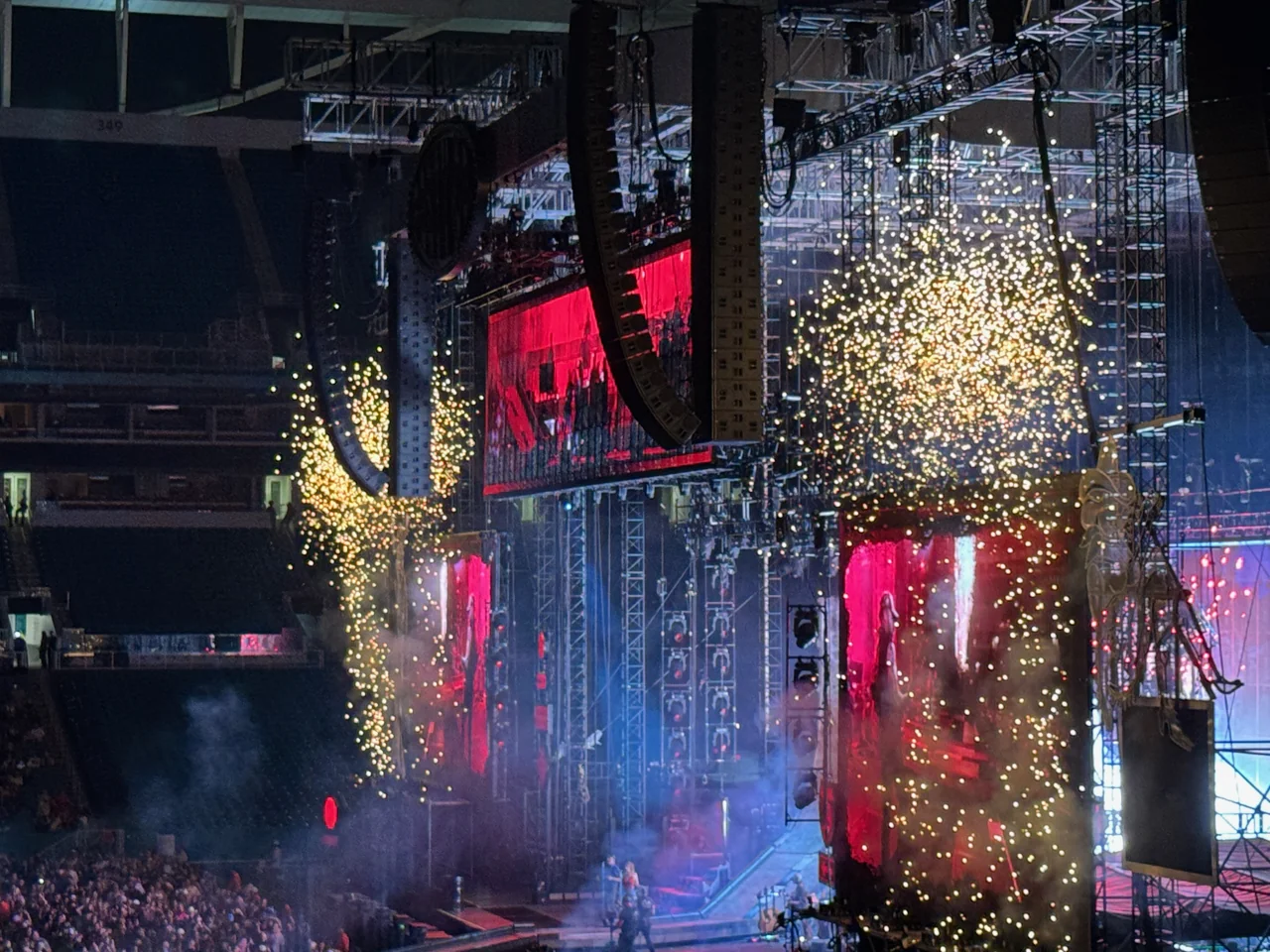 Post Malone’s stadium stage beneath falling gold sparks, flanked by red video screens.