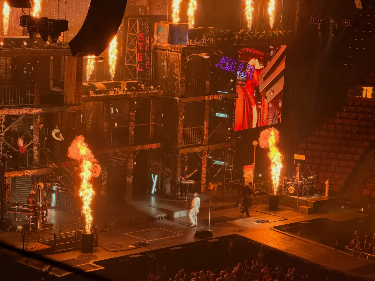 Teddy Swims onstage between columns of flame.