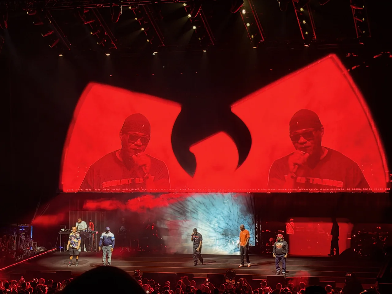 Wu-Tang Clan onstage beneath a red W-shaped screen.